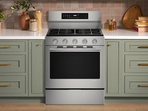 A gas range in a bright kitchen with white countertops